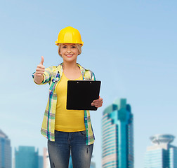 Image showing smiling woman in helmet with clipboard