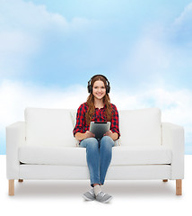 Image showing girl sitting on sofa with headphones and tablet pc