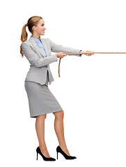 Image showing smiling businesswoman pulling rope