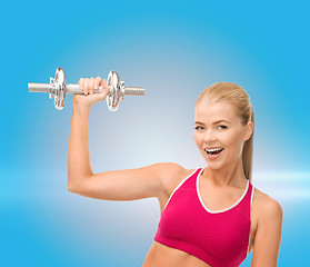 Image showing smiling woman with heavy steel dumbbell