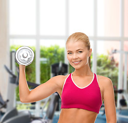 Image showing smiling woman with heavy steel dumbbell