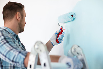 Image showing close up of male in gloves holding painting roller