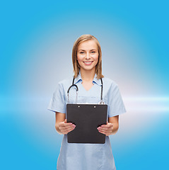 Image showing smiling female doctor or nurse with clipboard