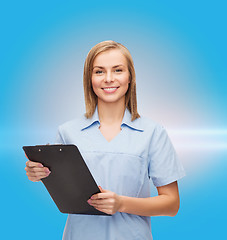 Image showing smiling female doctor or nurse with clipboard