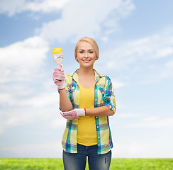 Image showing smiling woman with paintbrush