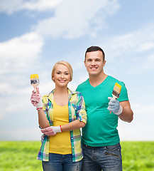 Image showing smiling couple with paintbrush