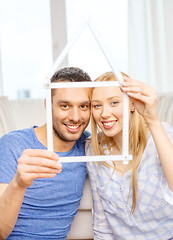 Image showing smiling couple with house from measuring tape