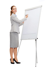 Image showing smiling businesswoman writing on flip board