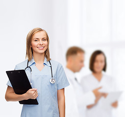 Image showing smiling female doctor or nurse with clipboard