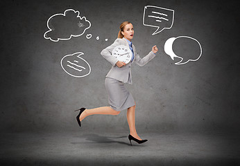 Image showing stressed young businesswoman with clock running