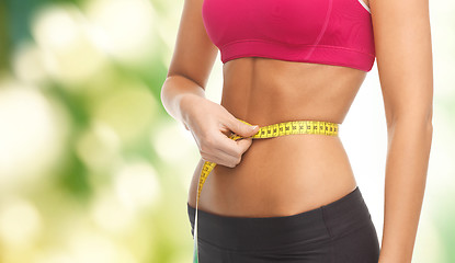 Image showing close up trained belly with measuring tape