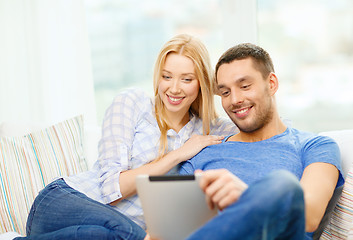 Image showing smiling happy couple with tablet pc at home