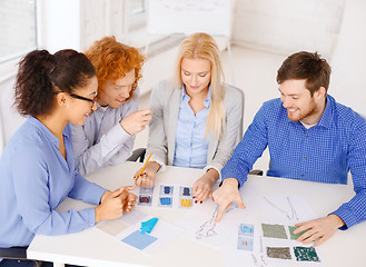 Image showing smiling creative team looking at sketch