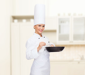 Image showing smiling female chef with pan and spoon