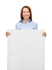 Image showing smiling businesswoman with white blank board