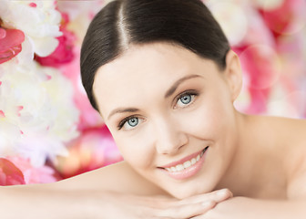 Image showing smiling woman in spa lying on the massage desk