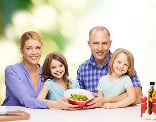 Image showing happy family with two kids with salad at home