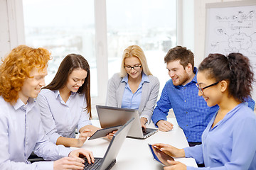 Image showing smiling team with laptop and table pc computers