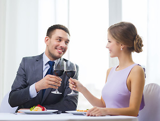 Image showing couple with main course and red wine at restaurant