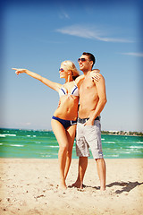 Image showing happy couple in sunglasses on the beach