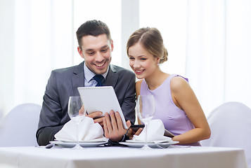 Image showing couple with menus on tablet pc at restaurant