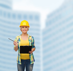 Image showing smiling woman in helmet with clipboard