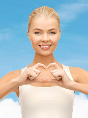 Image showing smiling woman showing heart shape gesture