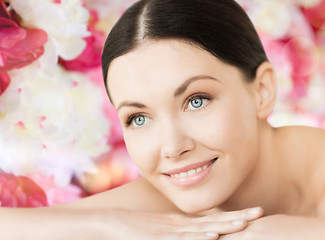 Image showing smiling woman in spa lying on the massage desk