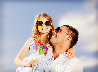 Image showing happy father and child in sunglasses over blue sky