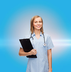 Image showing smiling female doctor or nurse with clipboard