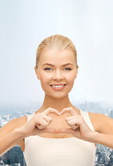 Image showing smiling woman showing heart shape gesture