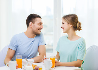 Image showing smiling couple having breakfast at home