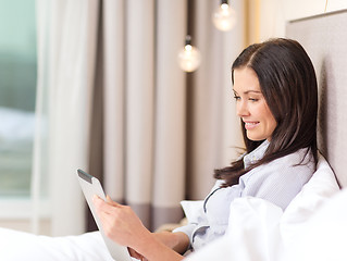 Image showing happy businesswoman with tablet pc in hotel room