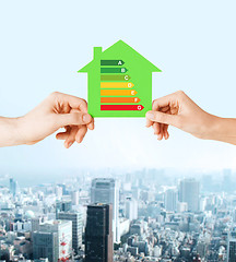 Image showing hands holding green paper house