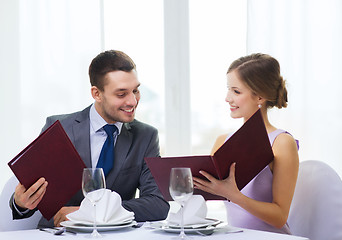 Image showing smiling couple with menus at restaurant