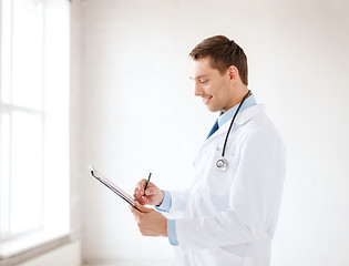 Image showing smiling male doctor with stethoscope and clipboard