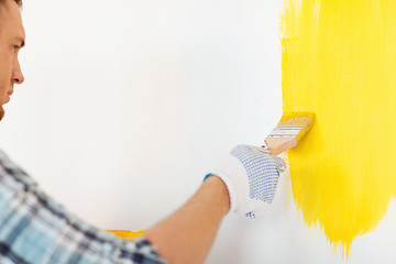 Image showing close up of male in gloves holding paintbrush