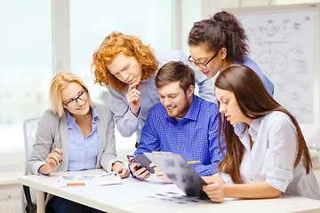 Image showing creative team with papers and clipboard at office