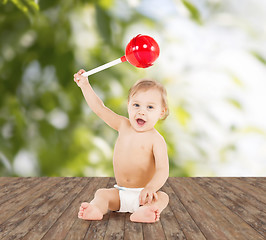 Image showing cute little boy playing with big lollipop