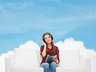 Image showing girl sitting on sofa with headphones and tablet pc