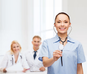 Image showing smiling female doctor or nurse with stethoscope