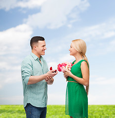 Image showing smiling couple with flower bouquet and ring