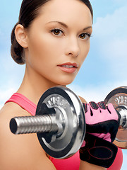 Image showing asian sporty woman with heavy dumbbell