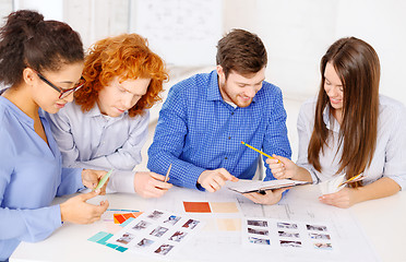 Image showing team with color samples and blueprint at office