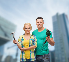 Image showing smiling couple with hammer and drill