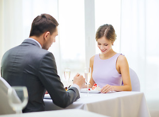 Image showing smiling couple eating dessert at restaurant