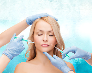 Image showing woman face and beautician hands with syringes