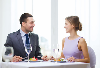 Image showing smiling couple eating main course at restaurant