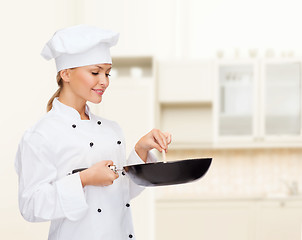 Image showing smiling female chef with pan and spoon