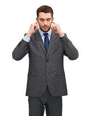 Image showing annoyed businessman covering ears with his hands